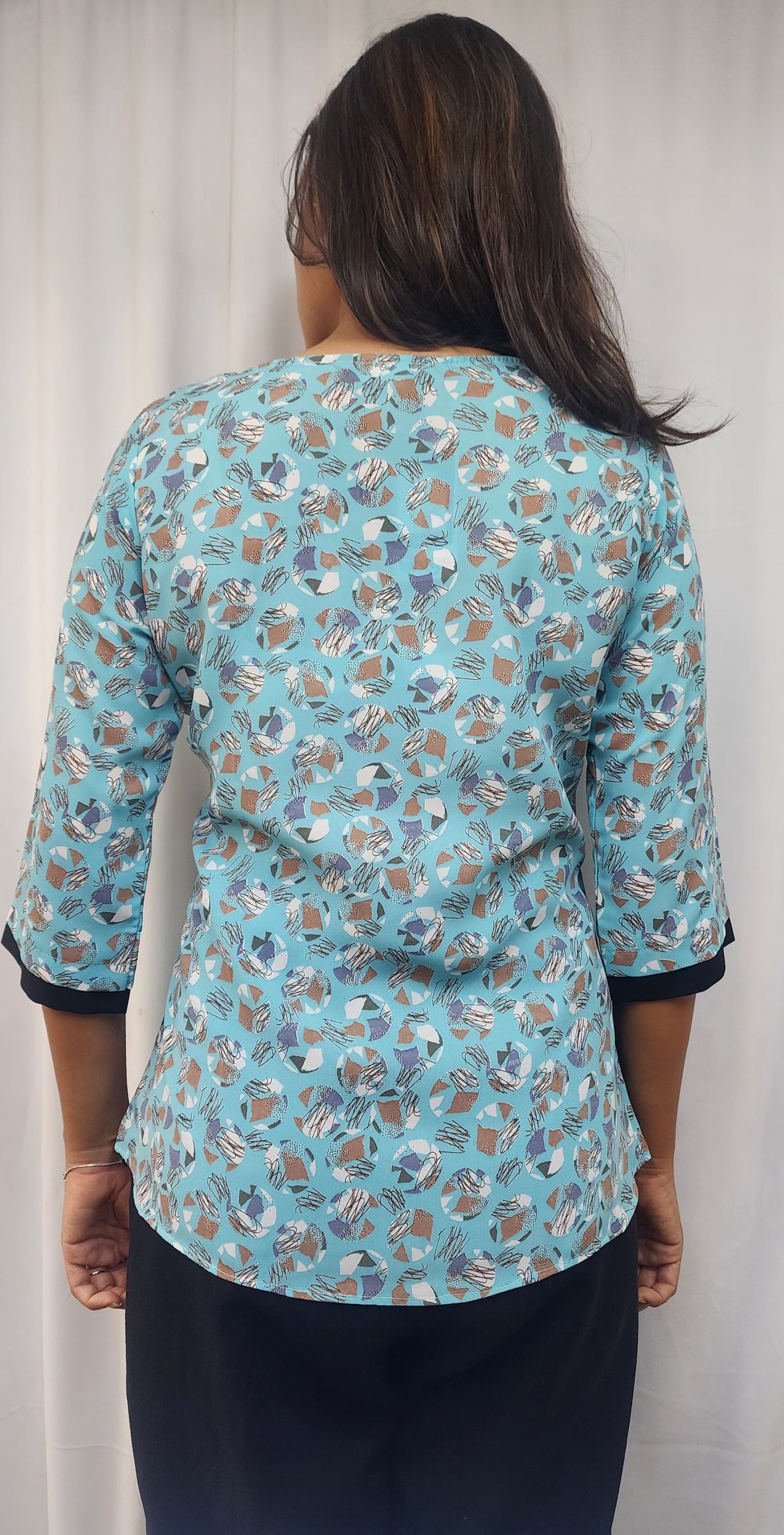 WOMENS ABSTRACT PRINTED TOP IN BLUE WITH ROUND NECK WITH BLACK DETAILING & BROOCH