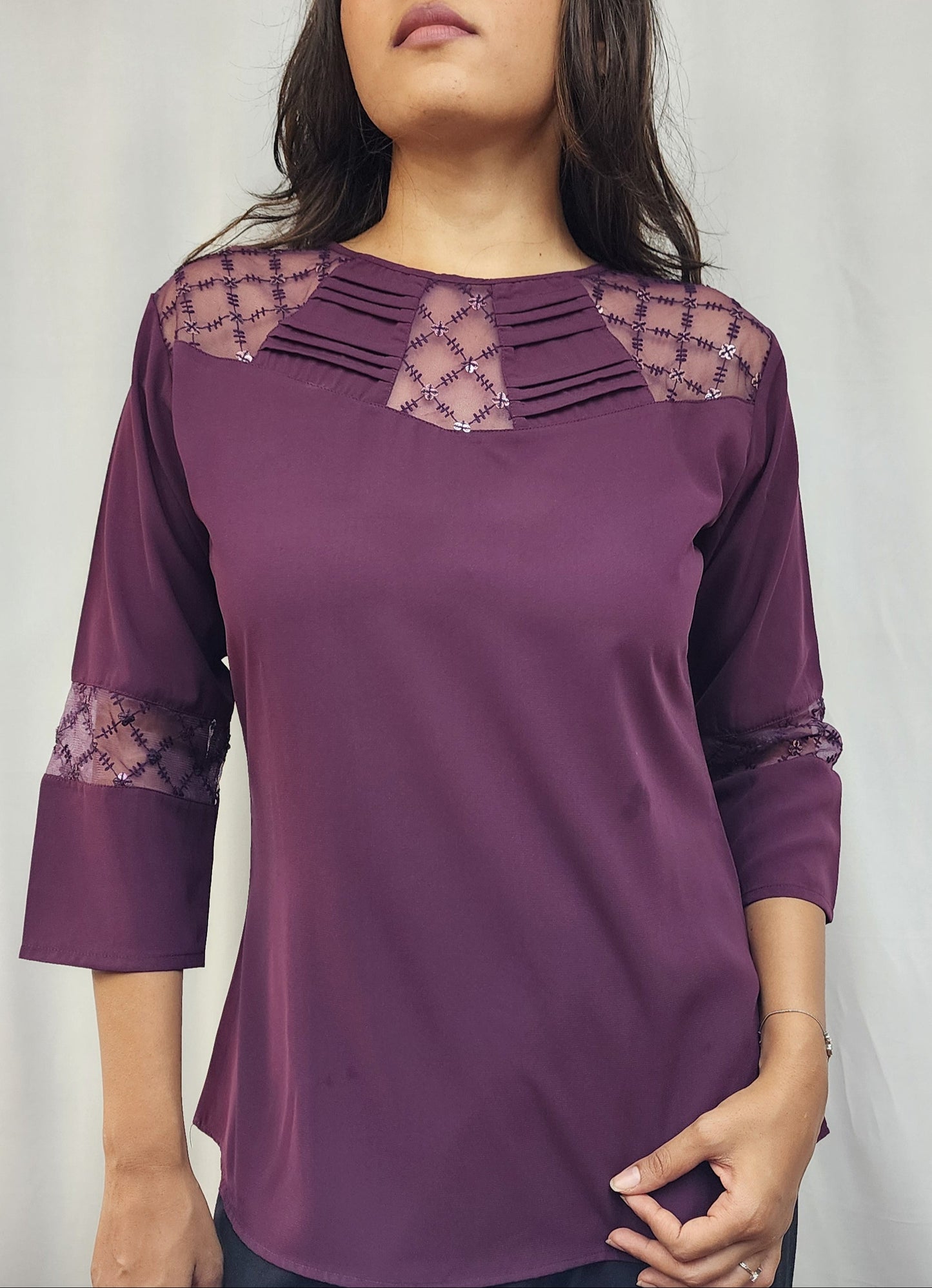 Woman wearing a purple blouse with lace details 