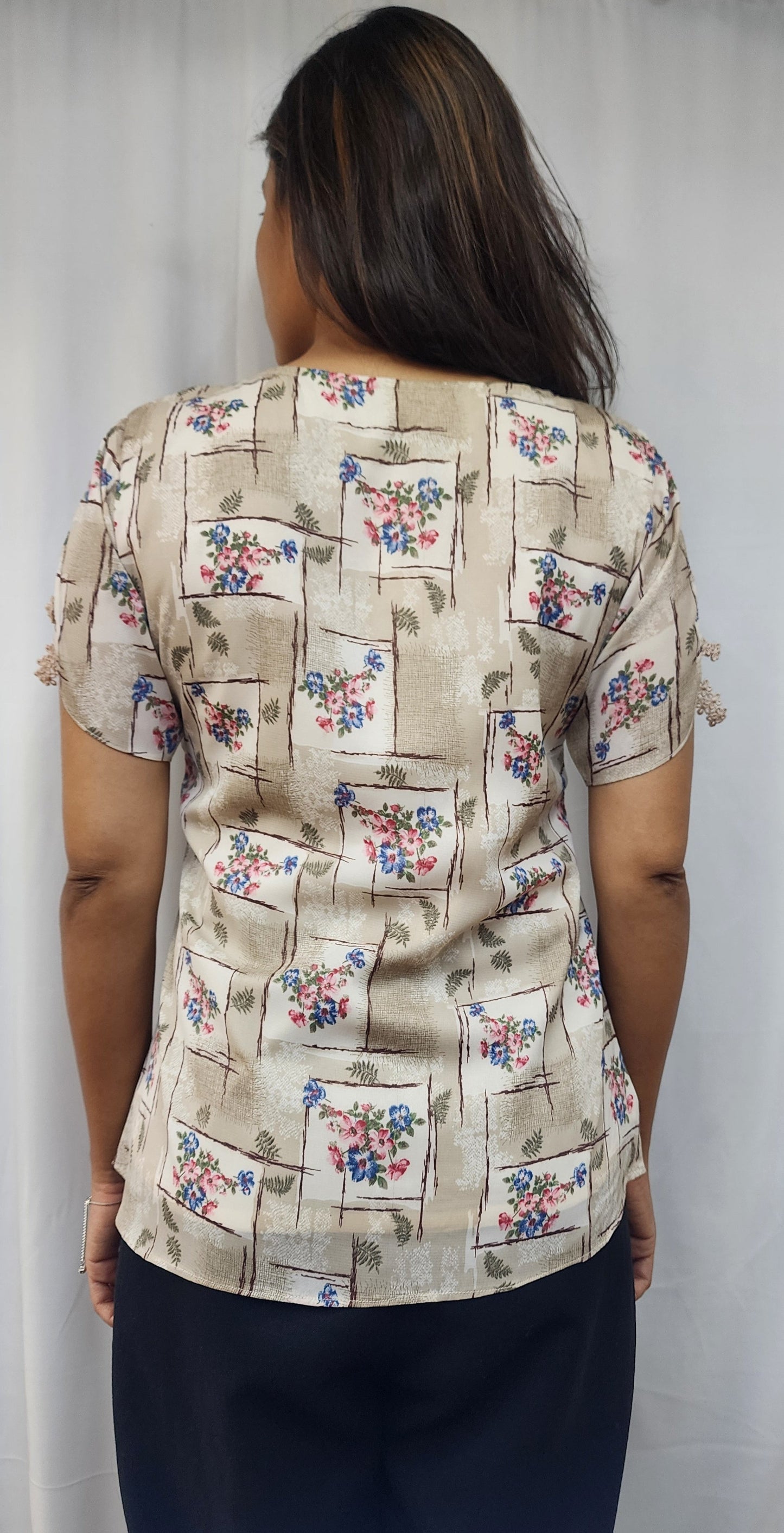 WOMENS ABSTRACT FLORAL PRINT TOP WITH PLEAT DETAIL & DIAMOND EMBELLISHMENT ON NECKLINE. LACE DETAILING ON SLEEVES