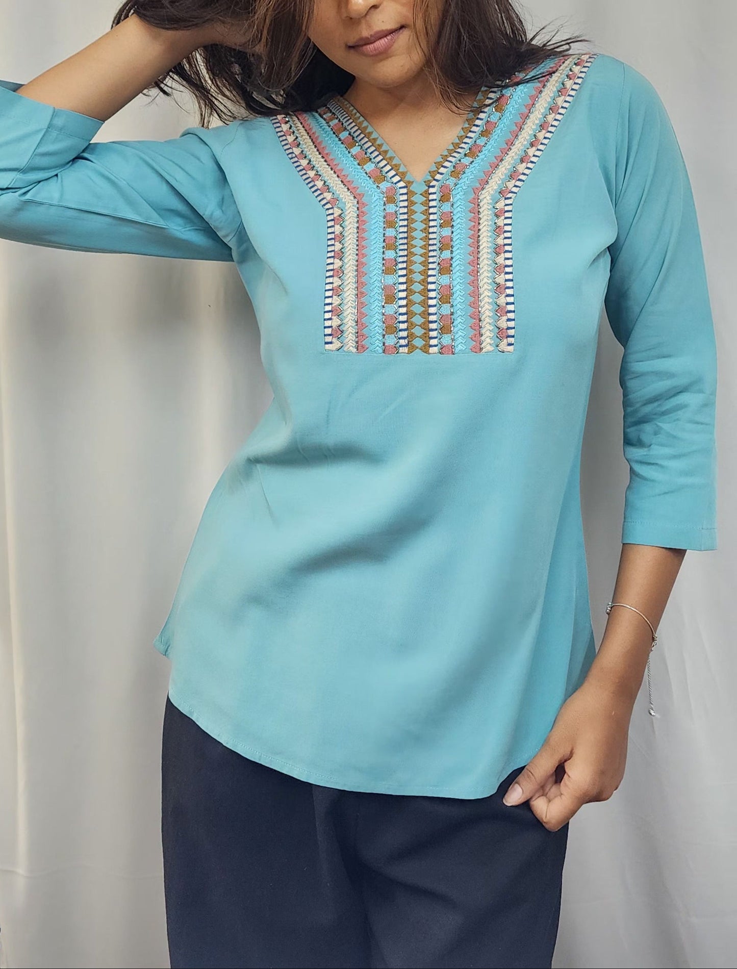 WOMENS SOLID EMBROIDERED TOP IN BLUE WITH V NECK, 3/4 TH SLEEVES, COLOURFUL GEOMETRIC EMBROIDERY ON THE YOKE