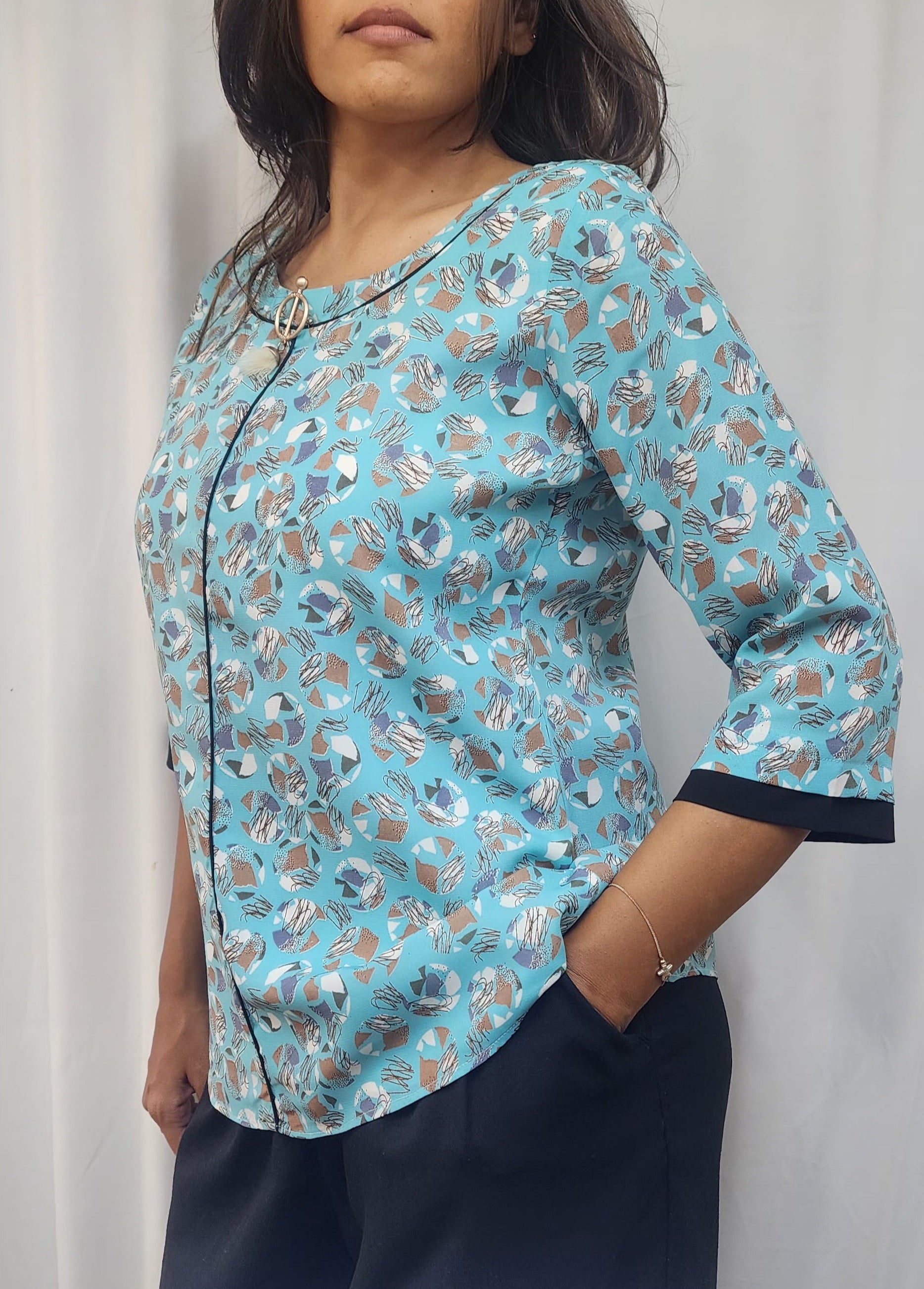 WOMENS ABSTRACT PRINTED TOP IN BLUE WITH ROUND NECK WITH BLACK DETAILING & BROOCH 