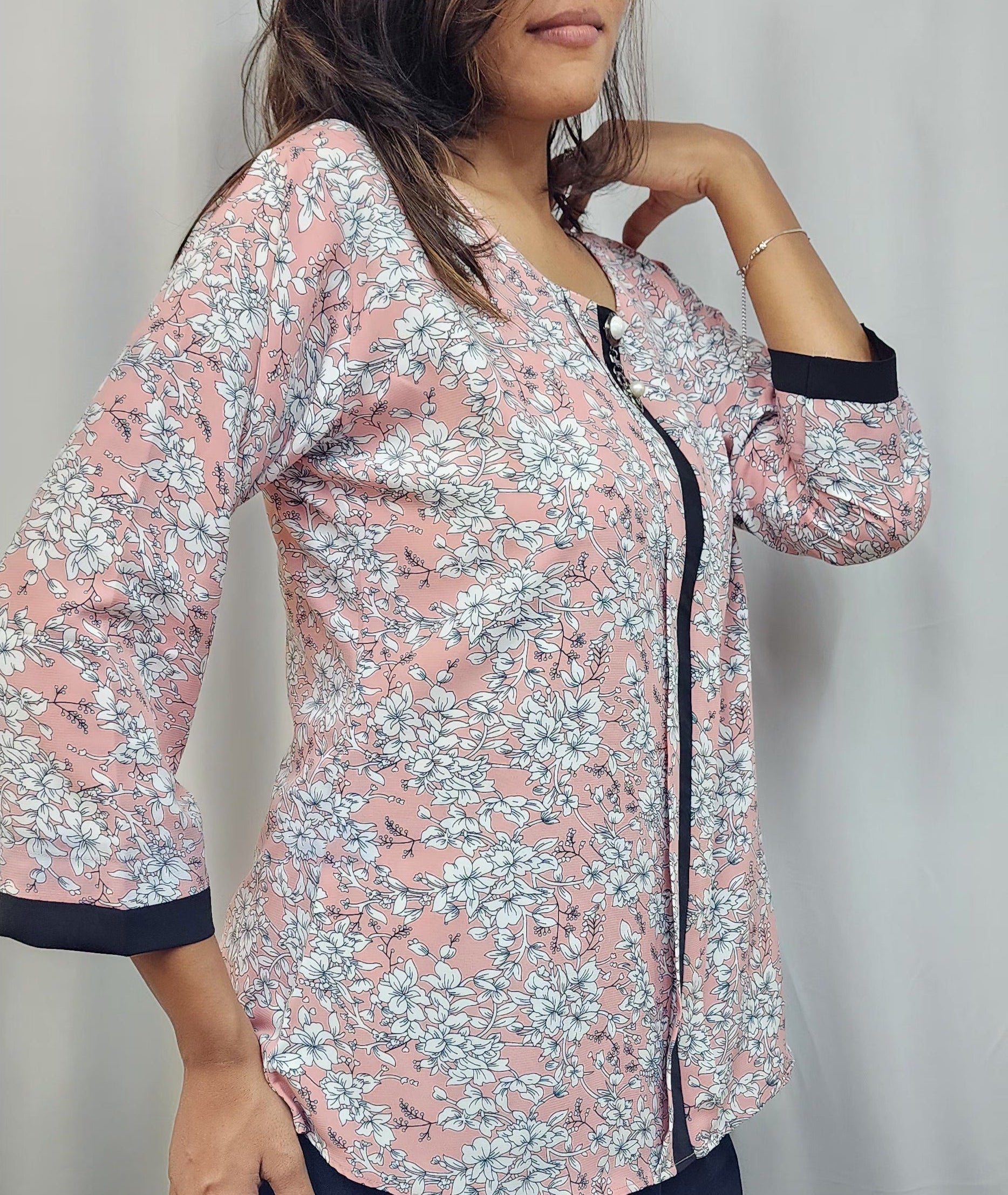 WOMENS FLORAL PRINTED TOP IN PEACK WITH ROUND NECK & BOX PLEAT IN THE FRONT. BLACK BAND DETAILING ON FRONT & SLEEVES. BROOCH ACCENT