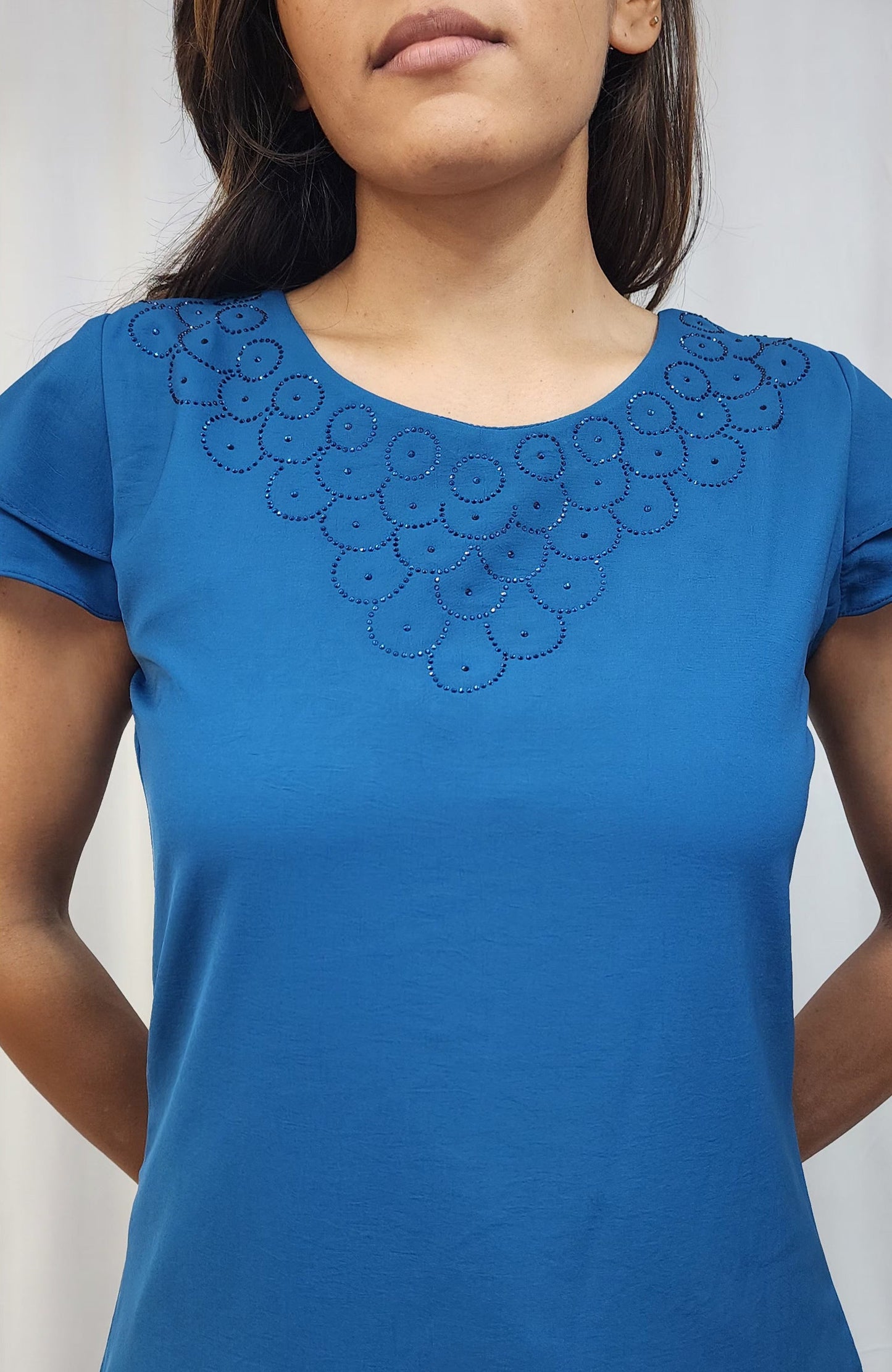 WOMENS SOLID TOP WITH DIAMOND EMBELLISHMENT. ROUND NECK, LAYERED RUFFLE SLEEVES.