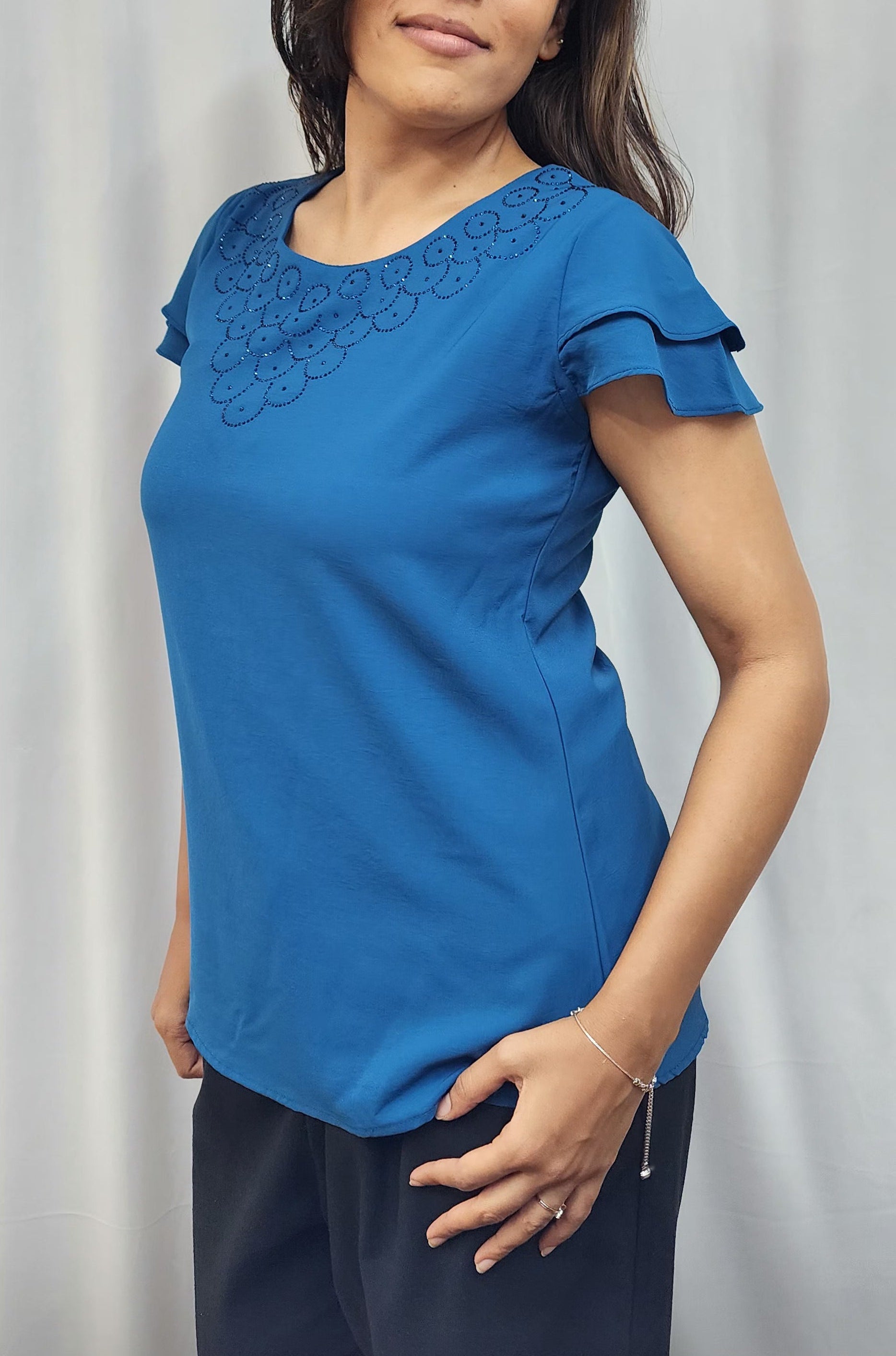 WOMENS SOLID TOP WITH DIAMOND EMBELLISHMENT. ROUND NECK, LAYERED RUFFLE SLEEVES.