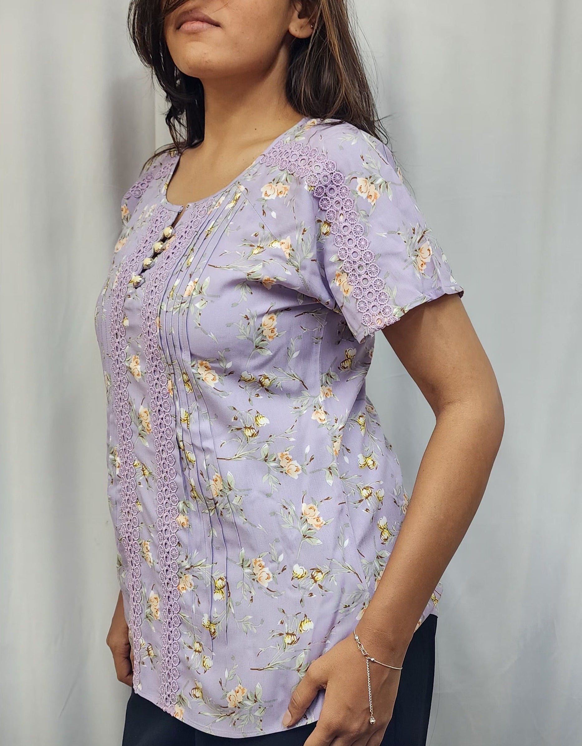 WOMENS FLORAL PRINTED TOP WITH LACE DETAILING. PINTUCKS ON FRONT PANEL, BUTTON ACCENTS ON ROUND NECK, SHORT  SLEEVES