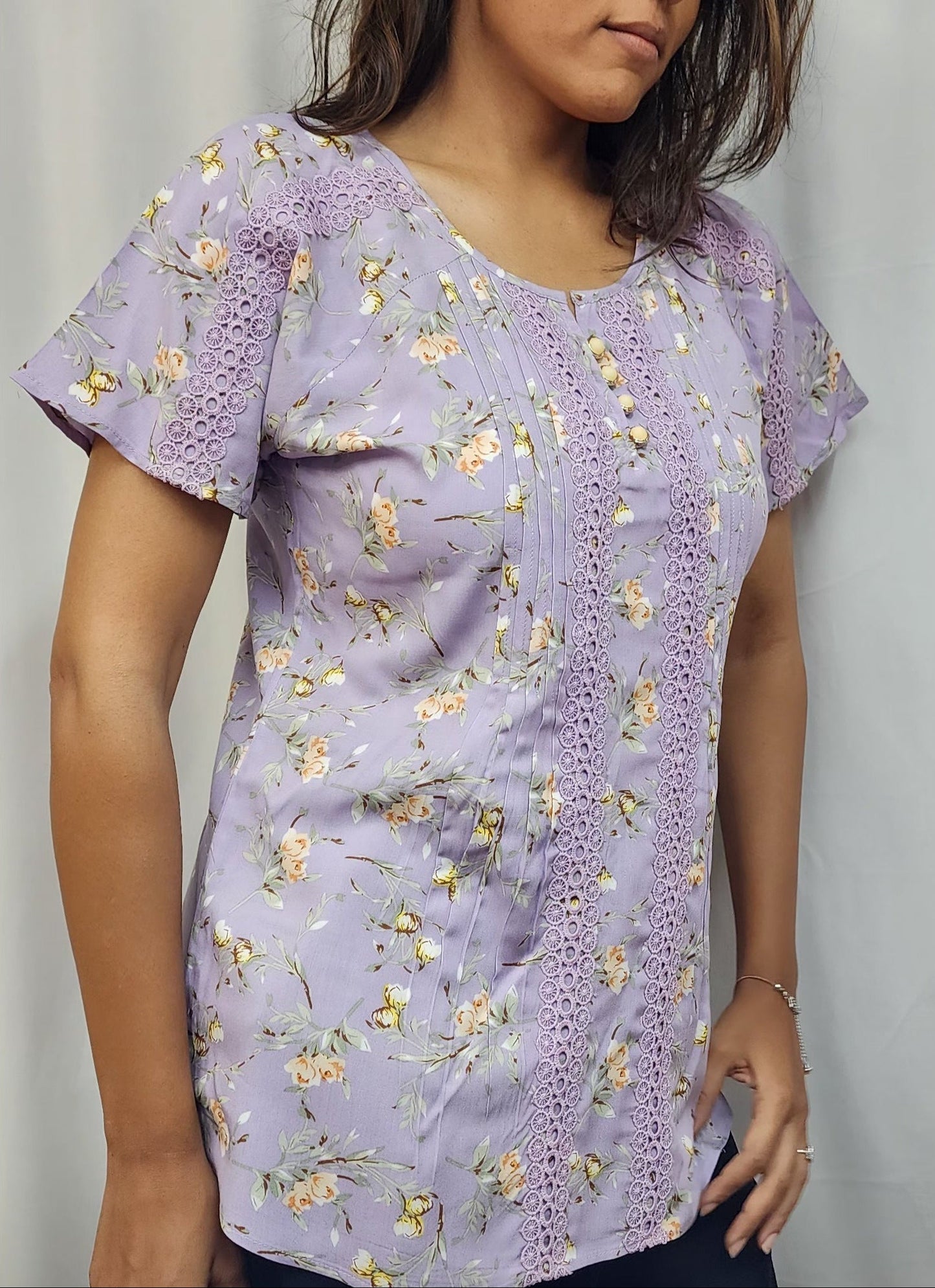 WOMENS FLORAL PRINTED TOP WITH LACE DETAILING. PINTUCKS ON FRONT PANEL, BUTTON ACCENTS ON ROUND NECK, SHORT SLEEVES